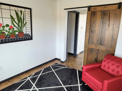 A sliding barn door made from reclaimed oak with a dark finish.